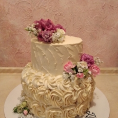Двухярусный торт с кремовыми завитками и живыми цветами